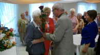 Mirosław Chmielarczyk i Anna Piaseczna podczas wręczania kwiatów 90-latce Kazimierze Marek