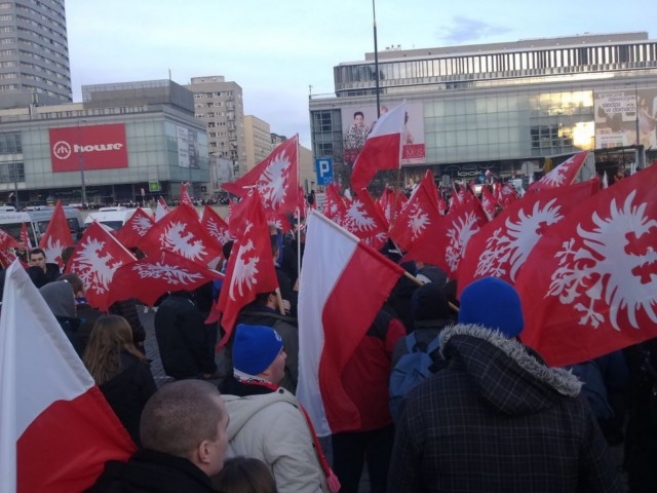 Z wielu zdjęć Patryka Krynickiego widać tylko od tyłu z flagą biało-czerwoną na tle flag Powstania Wielkopolskiego, które nieśli kibice Lecha Poznań